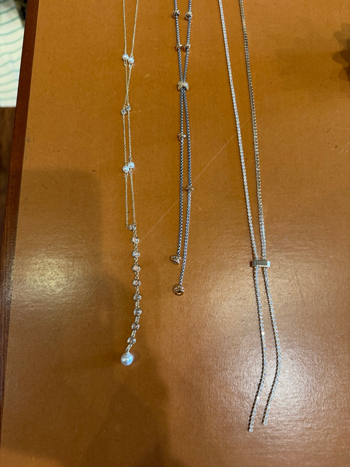 Assorted delicate long necklaces with crystal, pearl, and drop details