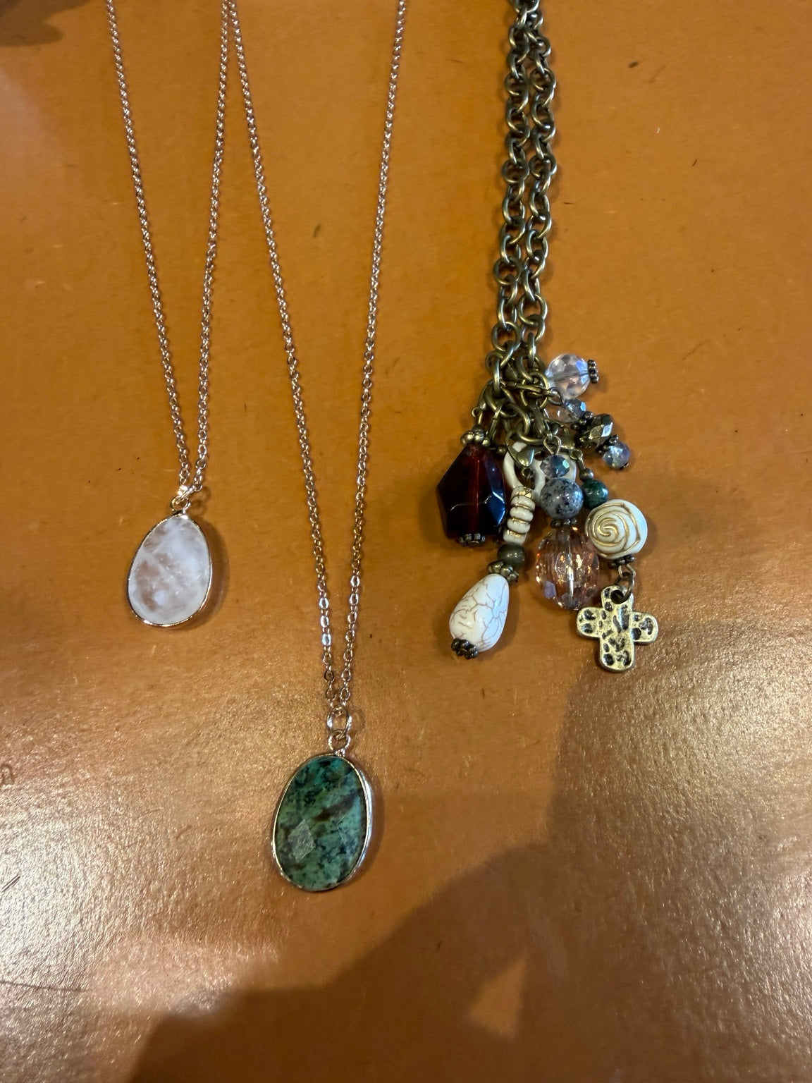 Three assorted necklaces with stone pendants and beaded charm cluster