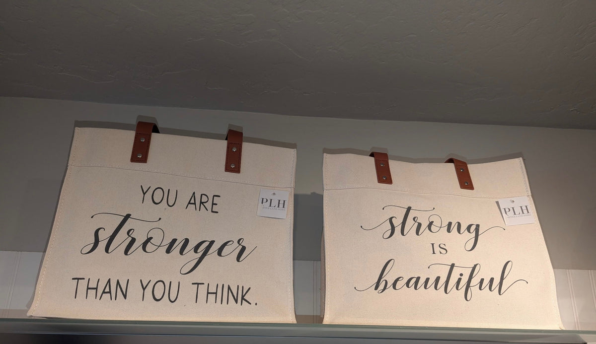 Cream canvas totes with brown handles: You Are Stronger Than You Think and Strong Is Beautiful