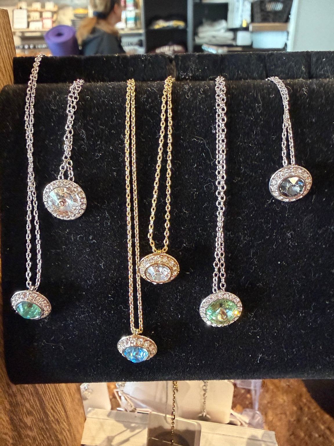 Assorted delicate crystal and charm necklaces on cards