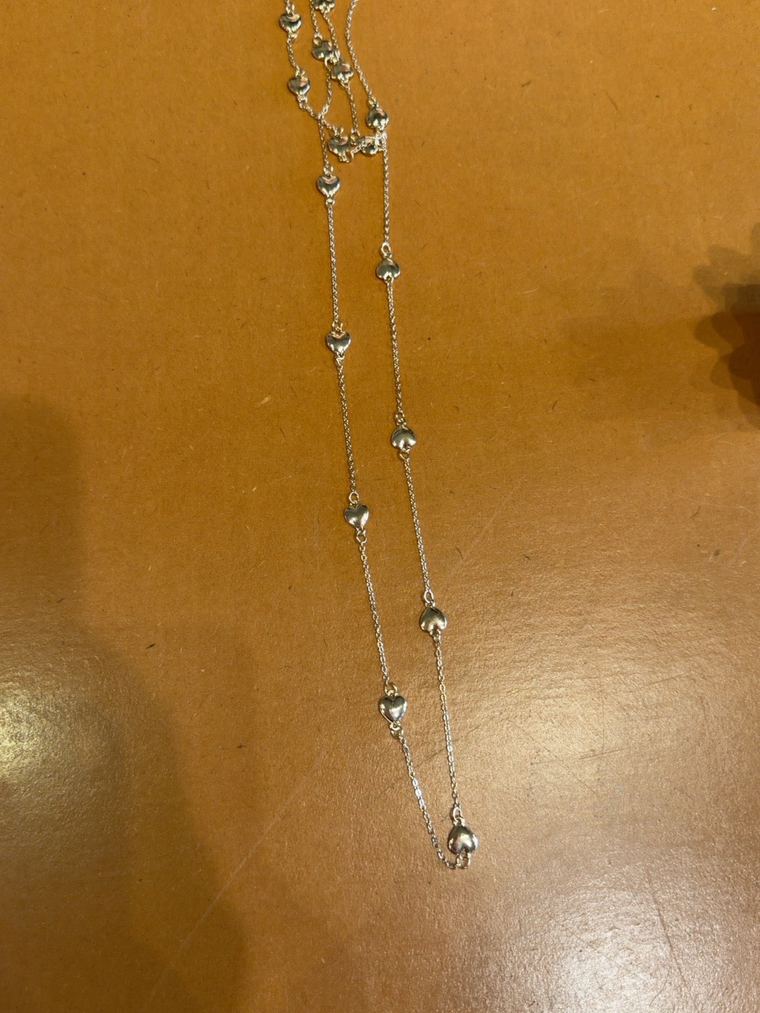 Long delicate gold-tone necklace with small heart charms